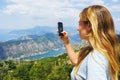 Traveler smartphone, landscape photography. Attractive girl takes story on smartphone while traveling mountains in Montenegro.