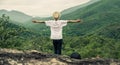 Traveler standing on the edge of a cliff and look around at the mountain