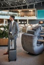 Traveler standing with his luggage at the waiting room Royalty Free Stock Photo