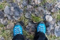 Traveler stands on a carpet of fallen leafs. Legs close up on the background of meadow landscape