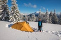 Traveler stands in a deep snow near a tent Royalty Free Stock Photo