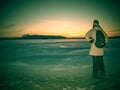 Traveler stay on ice of frozen sea. Woman with backpack