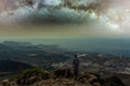 Traveler stays on top of mountain and enjoys the milky way view after sunset. Young tourist stand on the hill with colorful night Royalty Free Stock Photo