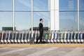 Traveler with suitcase next to row of luggage carts at airport Royalty Free Stock Photo