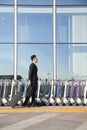 Traveler with suitcase next to row of luggage carts at airport Royalty Free Stock Photo