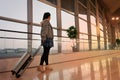 Traveler with suitcase walking with carrying luggage and passenger for tour in the airport terminal for air traveling Royalty Free Stock Photo