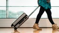 Traveler with suitcase walking with carrying luggage and passenger for tour in the airport terminal for air traveling Royalty Free Stock Photo