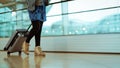 Traveler with suitcase walking with carrying luggage and passenger for tour in the airport terminal for air traveling Royalty Free Stock Photo