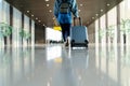 Traveler with suitcase walking with carrying luggage tour in the airport terminal for air traveling Royalty Free Stock Photo