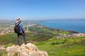 Traveler in sun hat with a backpack stands on the Mount Arbel top