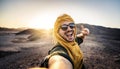 Happy traveler with backpack taking selfie picture with smart mobile phone outdoors Royalty Free Stock Photo