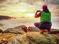 Traveler taking vacation mobile photos of beautiful sunset in autumn nature