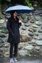 Traveler thai women holding umbrella and walking on the road at raining time