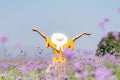 Traveler or tourism Asian women standing and raise hands chill in the purple verbena flower field in vacations time.