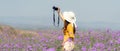 Traveler or tourism Asian women standing and holding camera take a photo flower in the purple verbena field in vacations time