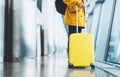 Traveler tourist with yellow suitcase backpack at airport on background large window, man in bright jacket waiting in departure Royalty Free Stock Photo