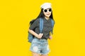 Traveler tourist young beautiful asian woman in hat and sunglasses with backpack,smiling and standing on yellow background.Summer