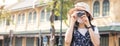 Traveler, travel asian young woman or girl use camera take photo, old town street, city tourism on happy sunny day. Backpacker Royalty Free Stock Photo