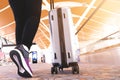 Traveler with travel bag or luggage walking in the airport terminal walkway for air traveling Royalty Free Stock Photo