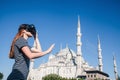 A traveler with virtual reality glasses. The concept of virtual travel around the world. In the background the blue