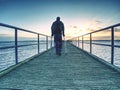 Traveler walking balance with forearm crutch on wooden bridge