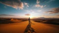 A traveler walking on the top of a sand dune in the desert. The man searching for the best way. Sunset sky, horizon. Royalty Free Stock Photo