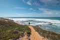 Traveler walks on a sandy path during a sunny day in Odemira region, western Portugal. Wandering along the Fisherman Trail, Rota