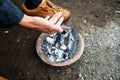 The traveler warms his hands near the stove with burning coals. Camping details, travel lifestyle photos Royalty Free Stock Photo