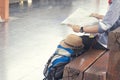 Traveler wearing backpack holding map, waiting for a train at trainstation and planing for next trip.