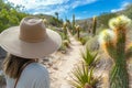 traveler in widebrimmed hat observing cacti on a desert trail Royalty Free Stock Photo