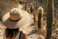 traveler in widebrimmed hat observing cacti on a desert trail Royalty Free Stock Photo