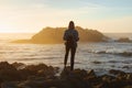 Traveler woman with backpack enjoying ocean view, girl hiker at sunset, travel concept, California, USA