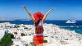 Traveler woman enjoys the view to the beautiful town of Mykonos island