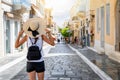 A traveler woman with hat enjoys the picturesque town of Andros, Cyclades, Greece