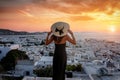 A traveler woman with hat enjoys the view over the town of Mykonos island Royalty Free Stock Photo