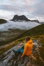 Traveler woman hiker sitting on cliff hiking in mountains outdoor travel in Norway Royalty Free Stock Photo