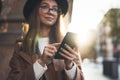 Traveler woman holding in hands mobile phone. Close up technology smartphone online connect. Girl hipster in glasses using gadget Royalty Free Stock Photo