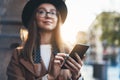 Traveler woman holding in hands mobile phone. Close up technology smartphone online connect. Girl tourist in glasses using gadget Royalty Free Stock Photo