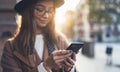 Traveler woman holding in hands mobile phone. Close up technology smartphone online. Girl tourist using gadget cellphone in sun Royalty Free Stock Photo