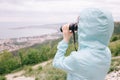 Traveler woman looking through binoculars on sea bay. Royalty Free Stock Photo