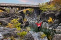 Woman near Venetikos river and Ruins of Eleftherochori stone bridge in Epirus, Greece at scenic autumn season