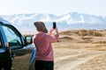 Traveler woman photographing with phone beautiful landscape in the autumn mountains