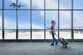 Traveler women plan and backpack see the airplane at the airport glass window. Asian tourist hold bag Royalty Free Stock Photo