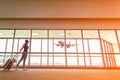 Traveler woman plan and backpack see the airplane at the airport glass window, girl tourist hold bag Royalty Free Stock Photo