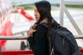 Traveler woman plan and backpack see airplane flight at the airport glass window, girl tourist happy hold bag Royalty Free Stock Photo