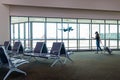 Traveler woman planning trip checking board pass at the airport glass window. Royalty Free Stock Photo