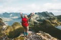 Traveler woman raised hands discovering mountains of Norway