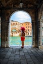 Traveler woman with a red hat enjoys the view to the architecture of the Canal Grande in Venice Royalty Free Stock Photo