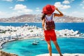 Woman stands on a hill over the beautiful town of Mykonos island Royalty Free Stock Photo