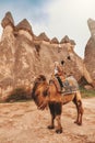 Traveler woman riding camel at Goreme fairy chimneys , Cappadocia. Nevsehir Province. Turkey Royalty Free Stock Photo